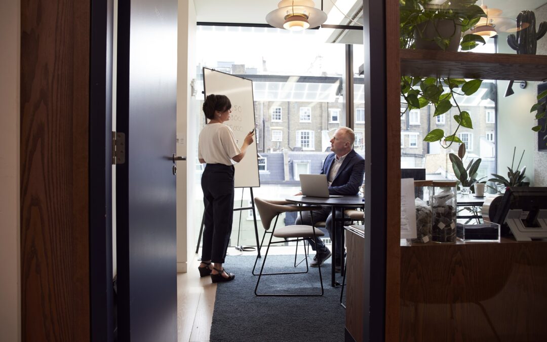 Woman speaking to man in board room